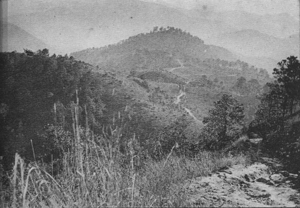 THE SWITZERLAND OF WESTERN CHINA

To travel in China is easy over country like this, granted that the
traveler sticks to the main road, sample of which is seen at lower
right.