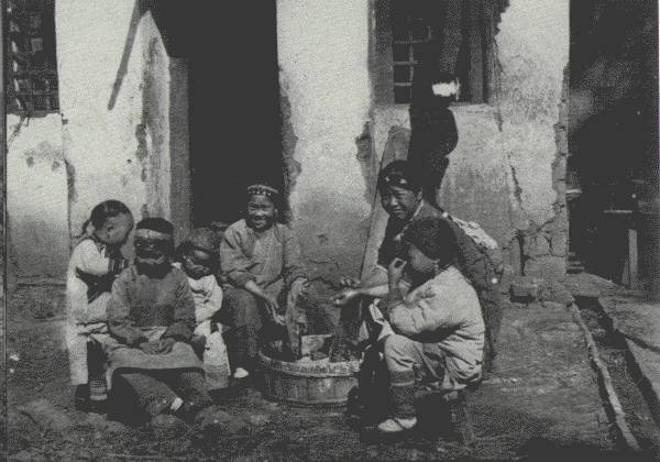 WASH DAY AMONG THE CHILDREN

Scene in the school grounds of the mission at Tongch'uanfu, the "City of
the Eastern Streams"—and a very happy little band they are.