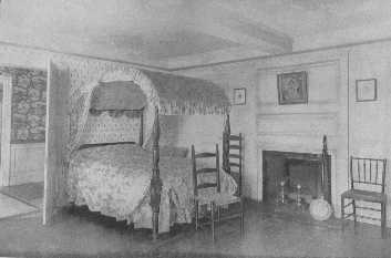 Dorothy Quincy's bedroom contains a fine old mahogany
field bed, which is appropriately covered with the flowered chintz
popular at the end of the Eighteenth Century. The chairs are fitting for
 all bedrooms decorated in Colonial style. Notice the woodwork in the
 room and hall.