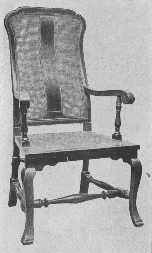 A reproduction of a walnut chair with cane seat and
back, of the William and Mary period.