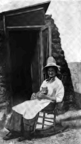 A happy homesteader in front of her "soddy." The vastness
of the country does not daunt her. She learns to love the quiet, broken
only by the roar of a river at the bottom of a canyon or the howl of a
coyote on the great sandy flats.