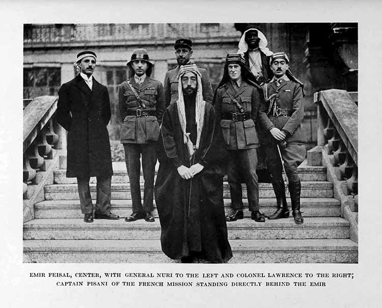 Photograph: EMIR FEISAL, CENTER, WITH GENERAL NURI TO THE LEFT
    AND COLONEL LAWRENCE TO THE RIGHT, CAPTAIN PISANI OF THE FRENCH
    MISSION STANDING DIRECTLY BEHIND THE EMIR