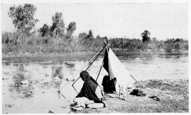 INDIAN WOMEN, POUNDING CLOTHES UPON THE ROCKS BESIDE A
SHALLOW BROOK, CEASED THEIR WORK TO STARE