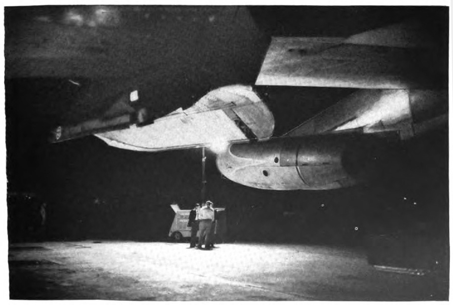 People next to an airplane at night